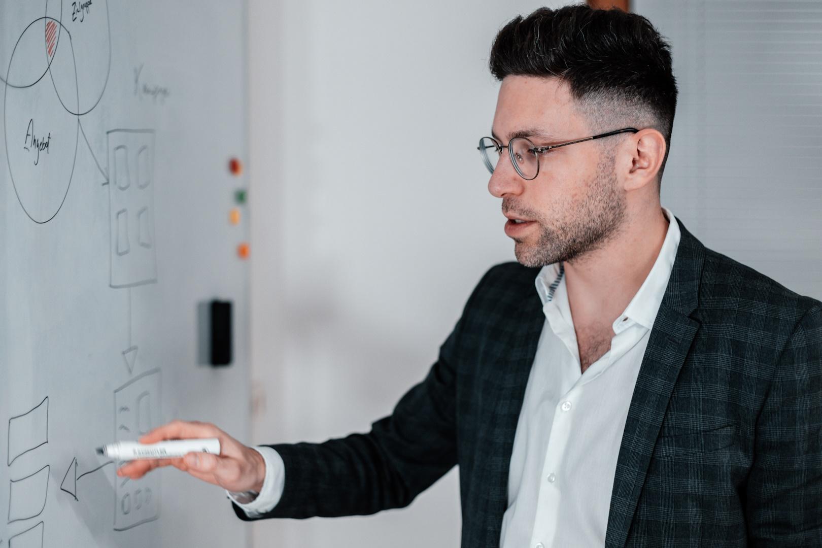 Albert Rossinski erklärt die Strategie an einem Whiteboard